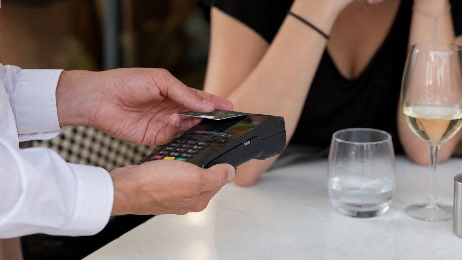 Terminal de paiement et pièces de monnaie illustrant les pourboires en carte et en espèces
